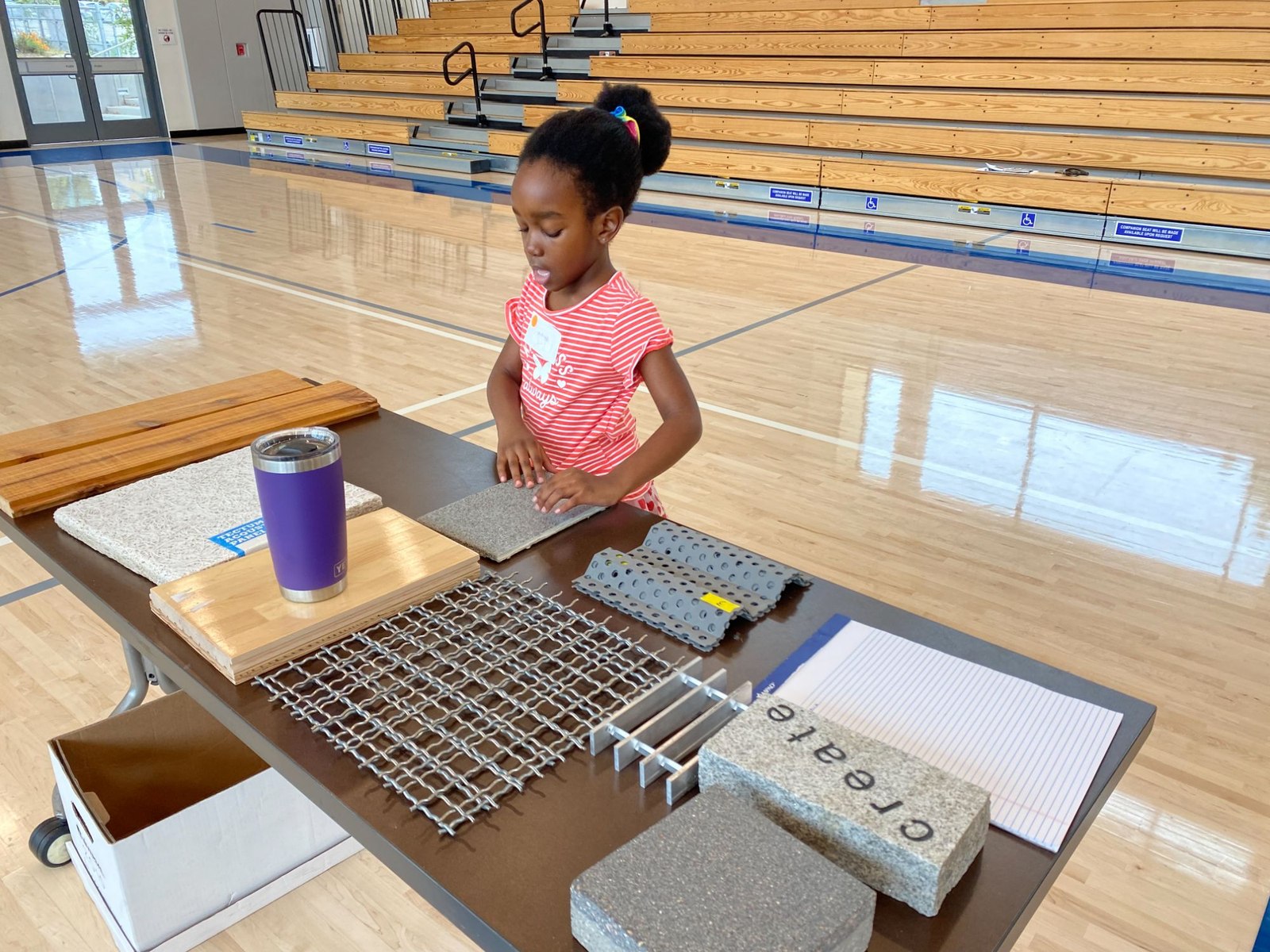 A child exploring building material samples on a table