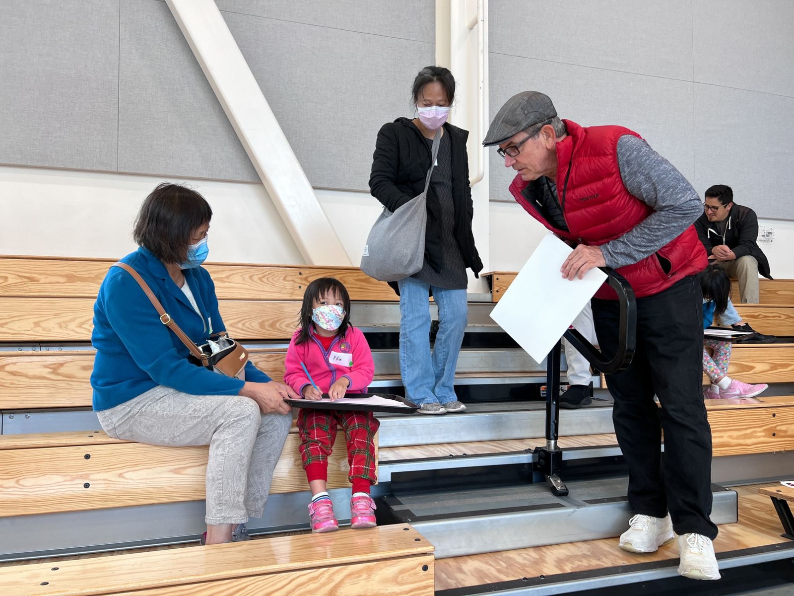 A family reviewing a sketch on a clipboard with a volunteer