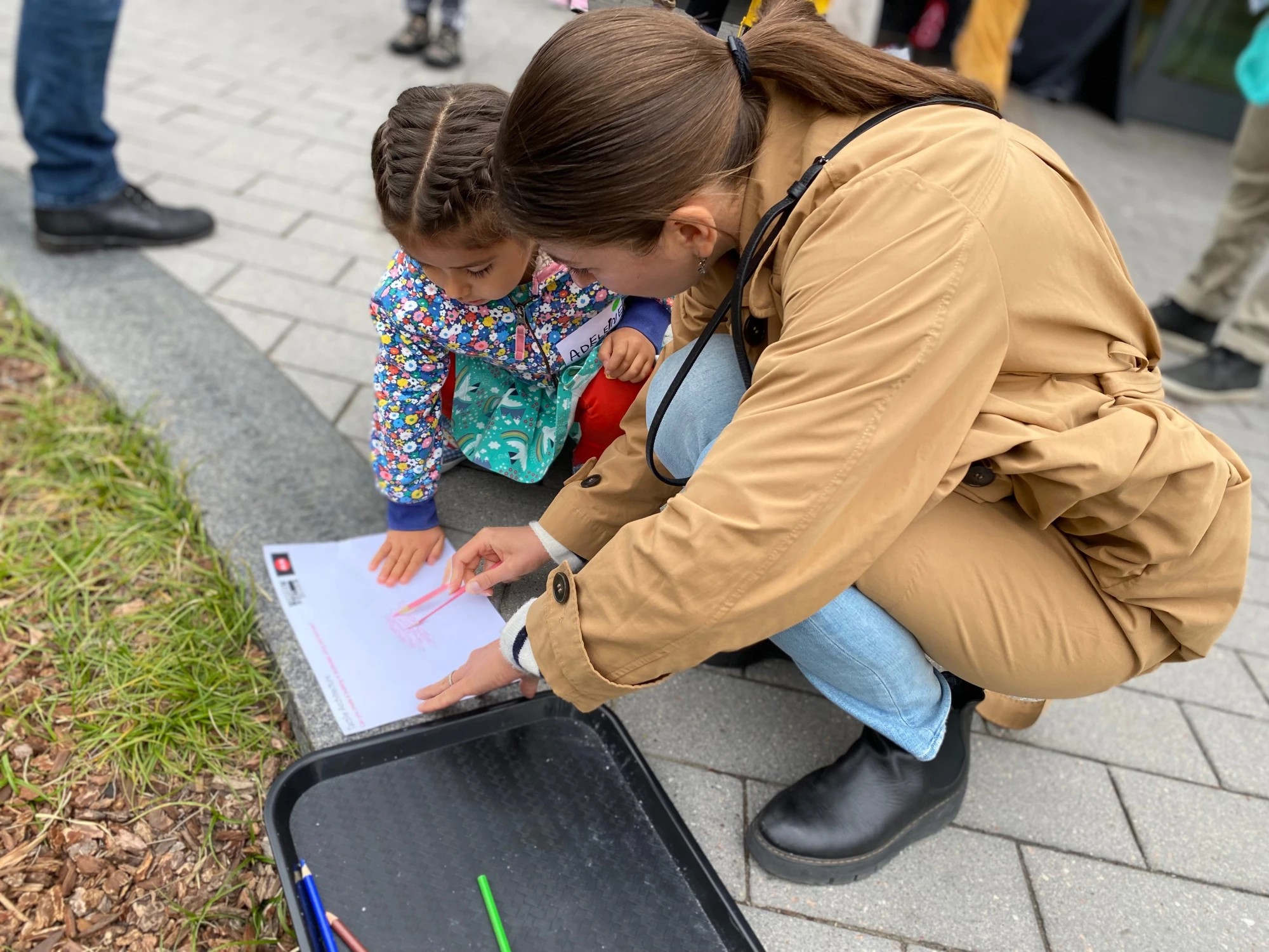 A young festival-goer drawing with help from a Center volunteer